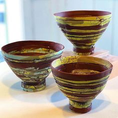 three brown and yellow vases sitting on top of a table