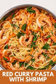 red curry pasta with shrimp and spinach in a skillet on a white background