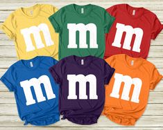 six t - shirts with m and m on them in multiple colors, all different