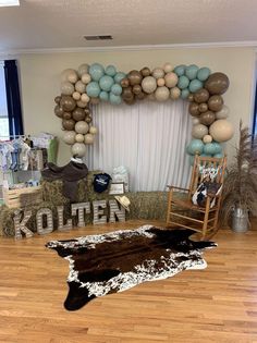 a living room filled with furniture and balloons in the shape of animals on hay bales