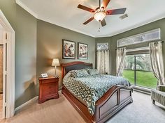 a bedroom with a large bed and ceiling fan