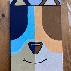 a painting of a dog's face on wood