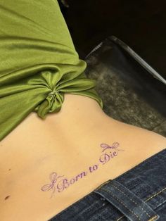 a woman's stomach with the words born to be tattooed on her lower back