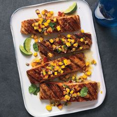 grilled fish with corn and cilantro garnish on a white platter