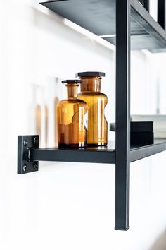 two glass jars sitting on top of a shelf