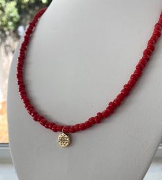 Red seed bead necklace with 18k gold plated charm and 18k gold filled lobster clasp. Perfect for layering or wearing alone. Gift Charm Necklaces With Single Strand And Round Beads, Gift Single Strand Charm Necklace With Round Beads, Dainty Red Beaded Necklaces With Round Beads, Dainty Red Beaded Necklace With Round Beads, Red Jewelry With Gold Beads For Gifts, Red Coral Necklace With Gold Beads For Gift, Red Beaded Necklace, Red Beaded Necklaces, Necklace Layering