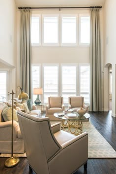 a living room filled with furniture and a fire place in front of a window on top of a hard wood floor