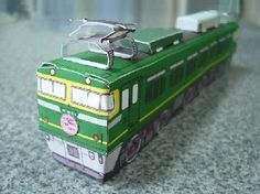 a green and white train car sitting on top of a table