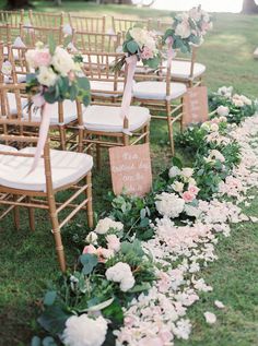 rows of chairs lined up with signs and flowers on the grass in front of them