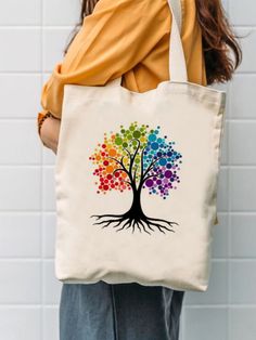 a woman carrying a colorful tree tote bag