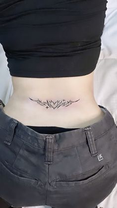 a woman's stomach with a small tattoo on her lower back, and the bottom half