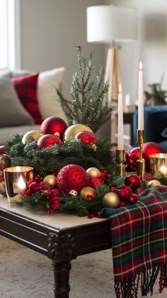 a living room decorated for christmas with candles, ornaments and decorations on the coffee table