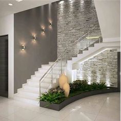 a modern house with stairs and plants in the entryway, along with lights on either side of the staircase