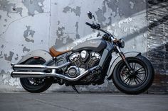 a black motorcycle parked in front of a wall