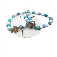 Dive into a sea of elegance with our handcrafted Turquoise Blue Turtle Bracelet. Each 8mm turquoise bead, reminiscent of serene ocean waves, is carefully strung to create a captivating flow of colour. The star of the show is its signature pearl turtle charm, meticulously carved to reflect the majestic beauty of sea turtles. With each detail reflecting the charm of ocean life, this one-of-a-kind bracelet evokes a sense of tranquillity and adventure. Its durable elastic design ensures a comfortabl Purple Jasper, Shell Wind Chimes, Blue Turtle, Bracelet Size Chart, Turtle Bracelet, Turtle Charm, Turtle Earrings, Turtle Necklace, Sea Glass Earrings