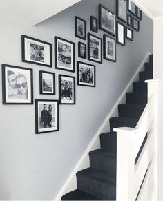 black and white photo frames on the wall next to stairs