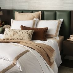 a neatly made bed with brown and white pillows