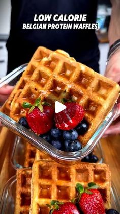 two waffles with strawberries and blueberries on top are shown in this ad