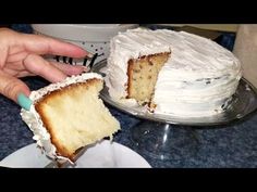 a person is holding a piece of cake in front of the cake on the plate