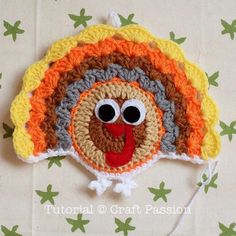 a crocheted turkey hat with eyes on it's side and a string in the middle