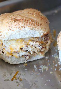 two sandwiches sitting on top of a metal pan covered in cheese and other toppings