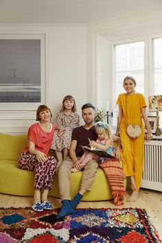 a group of people sitting on top of a yellow couch