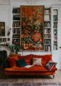 a living room with an orange couch and bookshelves