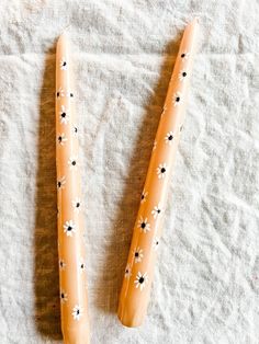 two plastic toothbrushes sitting on top of a white cloth covered table next to each other