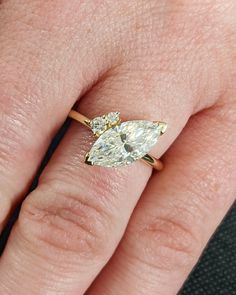 a woman's hand with a yellow and white diamond ring on top of her finger