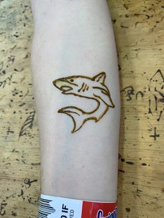 a person with a tattoo on their arm that has a shark drawn on the side