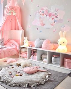 a bedroom with pink and white decor on the walls, bedding and rugs