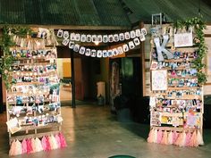 an outside area with pictures and decorations on the wall, along with photos hanging from wooden posts