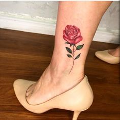 a woman's foot with a rose tattoo on it