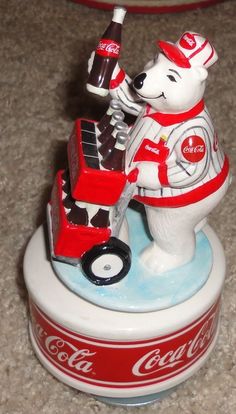 a coca - cola bear is riding a toy truck