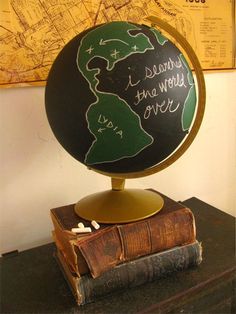 a globe with writing on it sitting on top of an old book