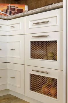 a kitchen with white cabinetry and marble counter tops