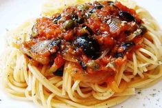 pasta with sauce and olives on a white plate