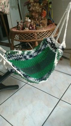 a green and white hammock sitting on top of a tiled floor