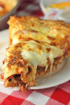 a slice of lasagna on a plate with a red and white checkered tablecloth