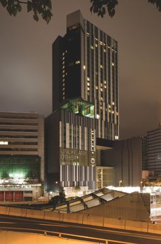 a very tall building sitting in the middle of a city at night with lights on