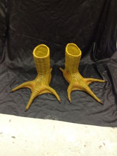 two yellow vases sitting on top of a black cloth