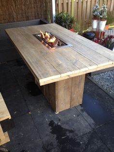 a wooden table with an open fire pit on top