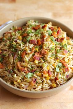 a bowl filled with rice and vegetables on top of a table