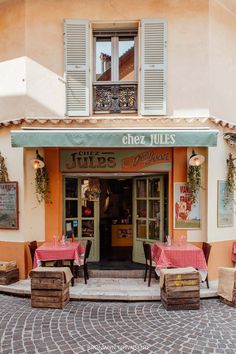 the outside of a restaurant with tables and chairs