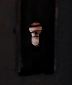 a person's eye is seen through a hole in the wall