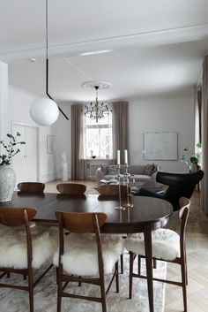 the dining room table is surrounded by chairs and rugs with white fur on them