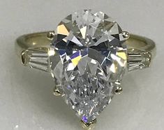 an oval cut diamond ring with baguets on the side