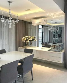 a dining room table with chairs and chandelier hanging from it's ceiling