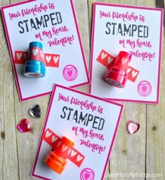 three valentine's day cards with stamps on them and some candy in the background