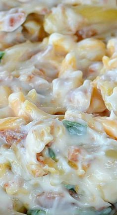 a close up view of some type of pasta casserole with cheese and spinach